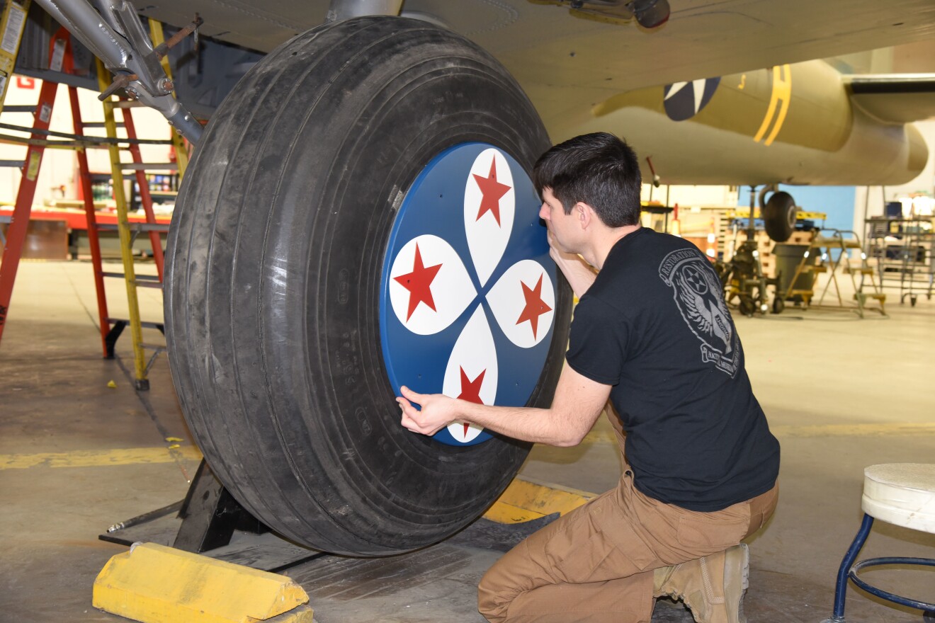 Museum restoration specialist Casey Simmons test-fits the wheel covers on the Boeing B-17F Memphis Belle.